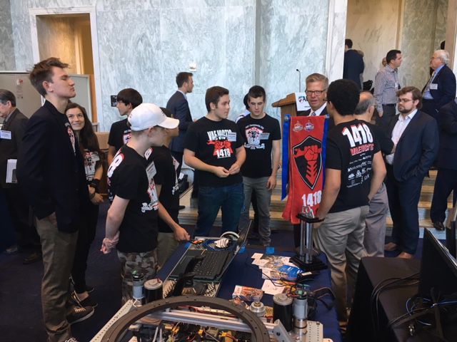 The team huddling around the robot.