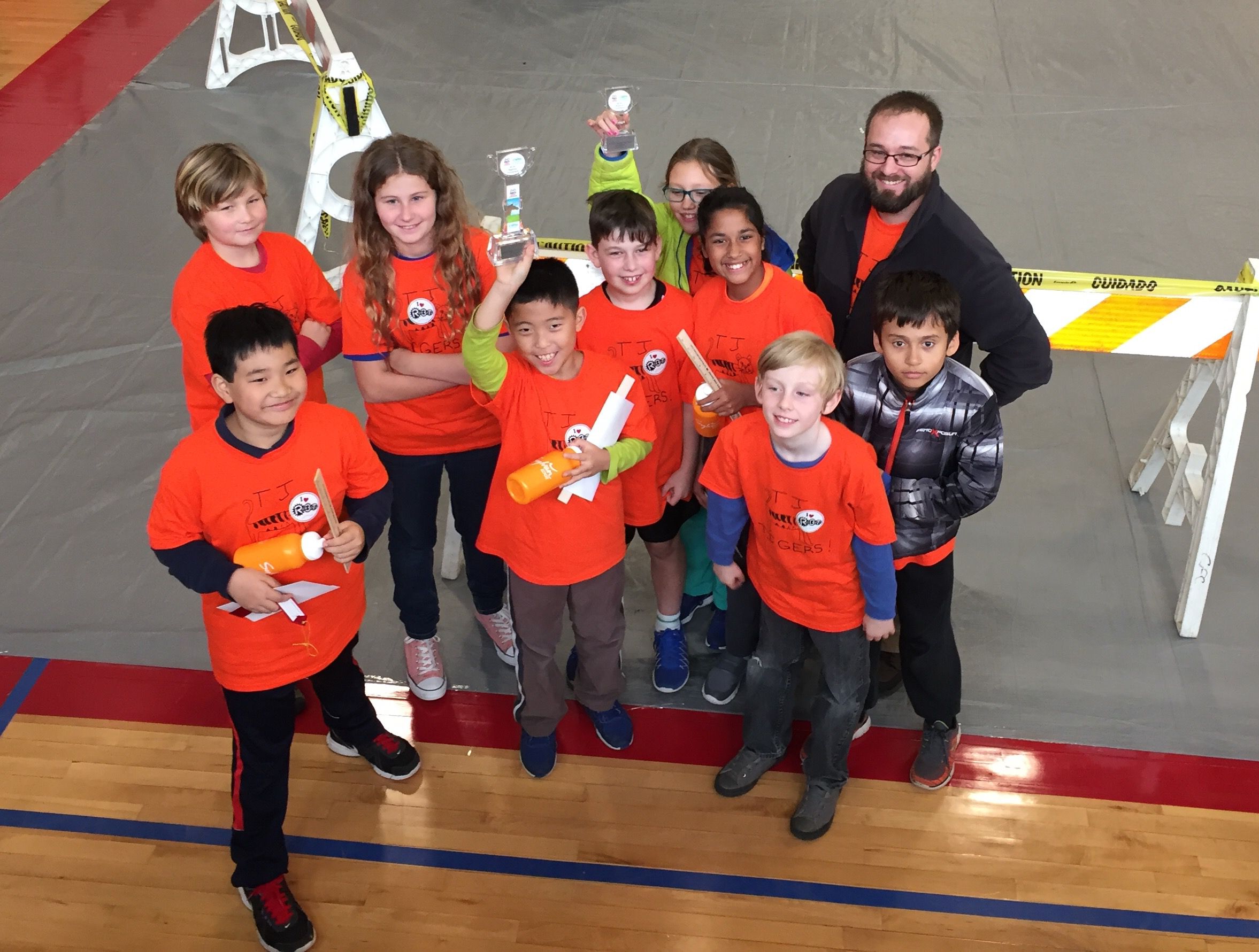 Students in red shirts posing and smiling.