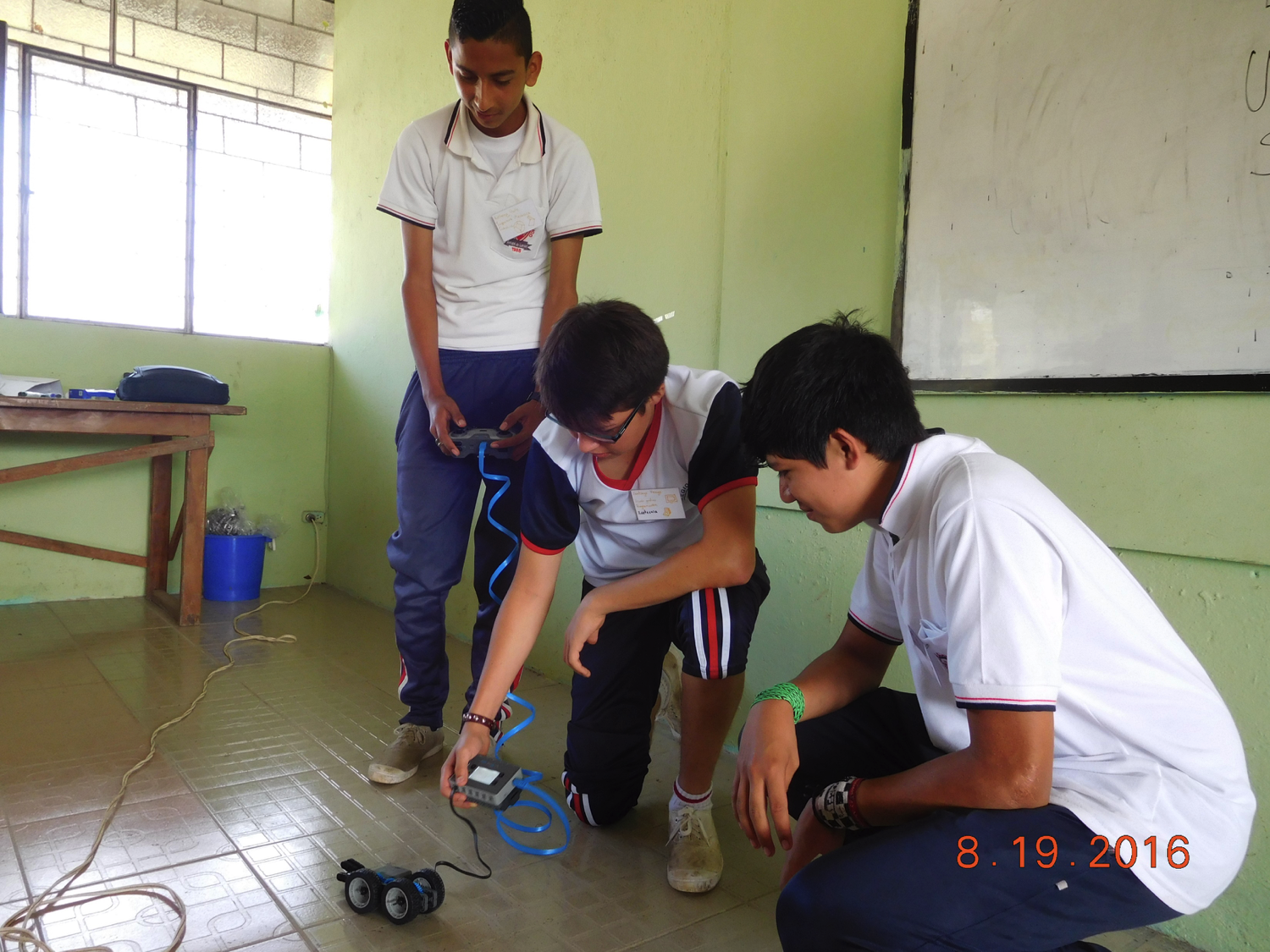 Three San Miguel de los Bancos testing their robot.