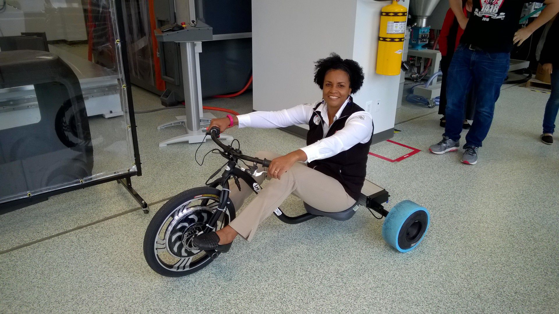 An adult smiling on a bike.